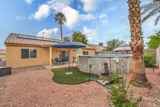 4006 Clove Tree Ct, North Las Vegas, NV 89031 - back of house with stucco siding, roof mounted solar panels, a tiled roof, a fenced backyard, and a gazebo