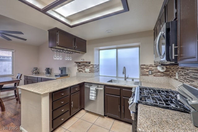 4006 Clove Tree Ct, North Las Vegas, NV 89031 - kitchen featuring stainless steel appliances, light countertops, a peninsula, and backsplash
