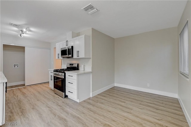 4512 Mark Ave, Las Vegas, NV 89108 - kitchen featuring stainless steel appliances, light wood-style flooring, light countertops, and white cabinets