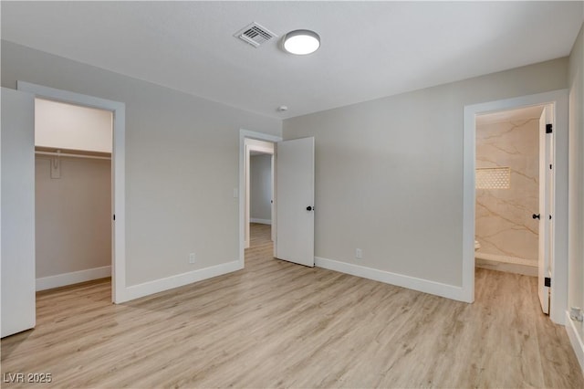 4512 Mark Ave, Las Vegas, NV 89108 - unfurnished bedroom featuring light wood-style flooring, a spacious closet, ensuite bath, and a closet