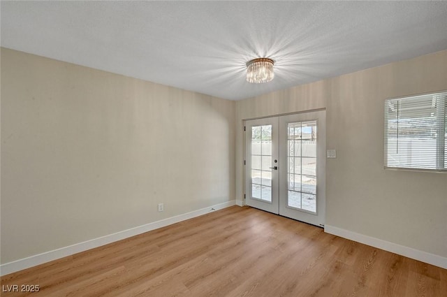 4804 Apawana Ln, Las Vegas, NV 89108 - spare room with french doors, light wood finished floors, and a chandelier