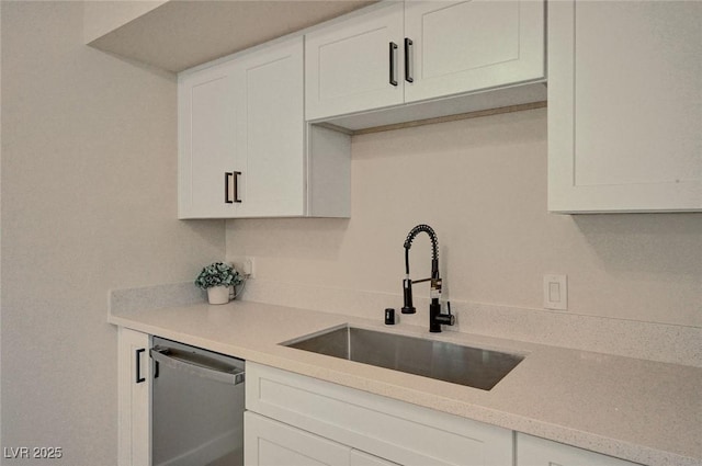 4804 Apawana Ln, Las Vegas, NV 89108 - kitchen with stainless steel dishwasher, white cabinetry, and light countertops