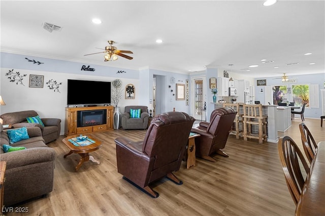 2606 Crested Butte St, Henderson, NV 89052 - living area featuring a ceiling fan, light wood-type flooring, recessed lighting, and crown molding