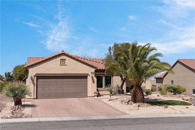 2606 Crested Butte St, Henderson, NV 89052 - view of front of house with a tile roof, a garage, stucco siding, and driveway
