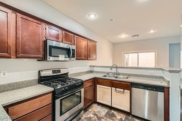 6349 Blushing Willow St, North Las Vegas, NV 89081 - kitchen with stainless steel appliances, a peninsula, light countertops, and recessed lighting