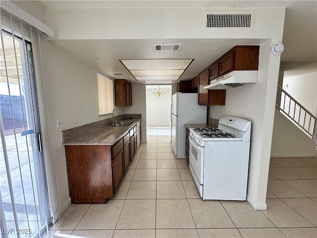 1332 Wheatland Way, Las Vegas, NV 89128 - kitchen with white appliances, under cabinet range hood, and light tile patterned floors