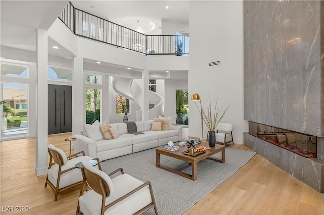8617 Titleist Cir, Las Vegas, NV 89117 - living room with a fireplace, wood finished floors, and a towering ceiling