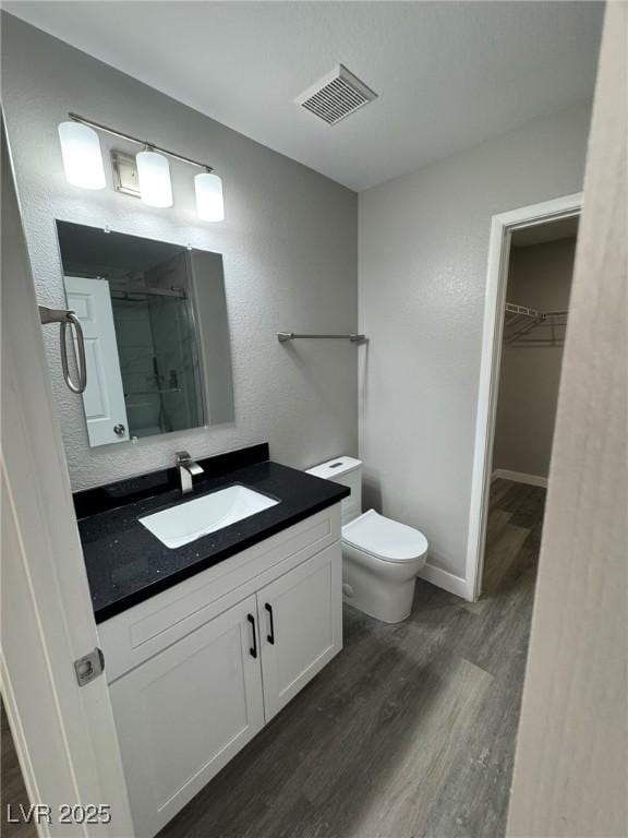 621 Carlos Julio Ave, North Las Vegas, NV 89031 - full bathroom with vanity, wood finished floors, a walk in closet, and a shower stall