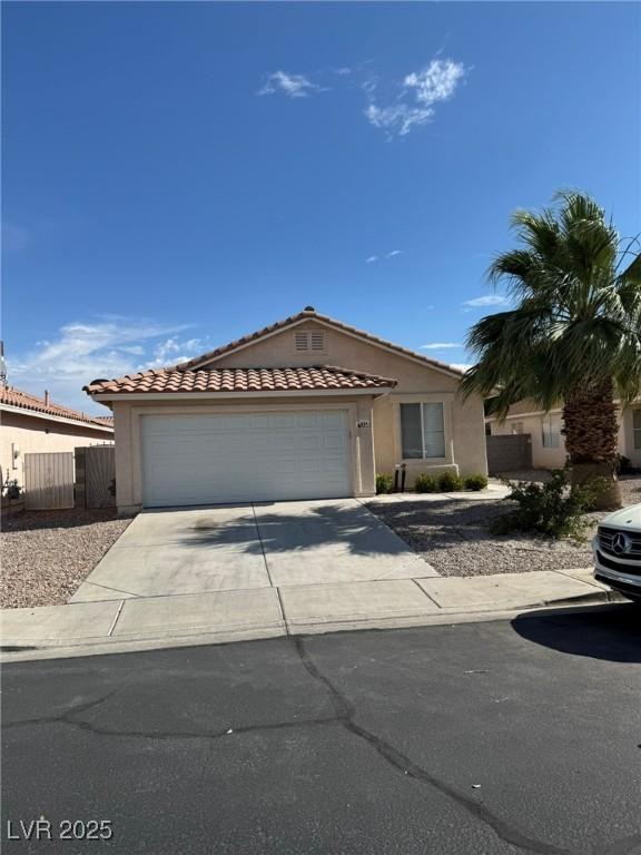 621 Carlos Julio Ave, North Las Vegas, NV 89031 - view of front of house with a garage, driveway, stucco siding, and a tiled roof