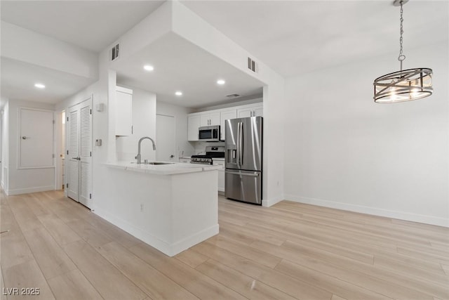 8250 N Grand Canyon Dr Unit 1050, Las Vegas, NV 89166 - kitchen featuring appliances with stainless steel finishes, light wood-style floors, white cabinets, recessed lighting, and a peninsula