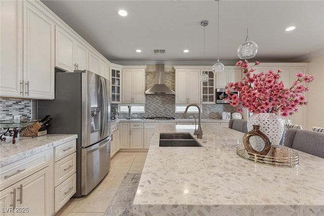 7112 Rancho De Taos Ct, Las Vegas, NV 89130 - kitchen with wall chimney exhaust hood, decorative backsplash, light tile patterned flooring, appliances with stainless steel finishes, and glass insert cabinets