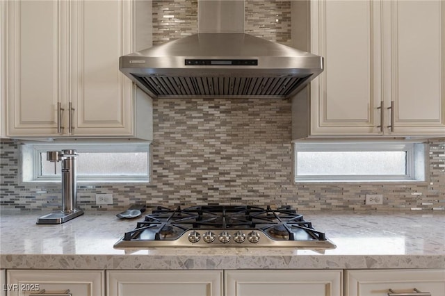 7112 Rancho De Taos Ct, Las Vegas, NV 89130 - kitchen featuring wall chimney exhaust hood, stainless steel gas cooktop, decorative backsplash, and light stone countertops