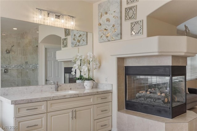 7112 Rancho De Taos Ct, Las Vegas, NV 89130 - bathroom featuring vanity, a multi sided fireplace, and a tile shower