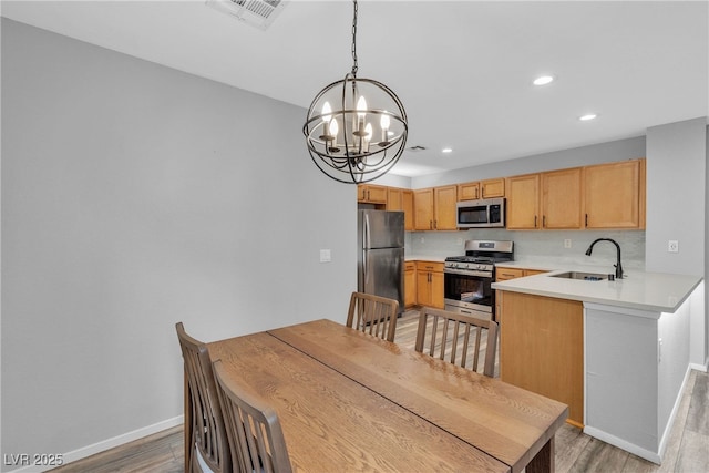 9074 Maycott Ave, Las Vegas, NV 89148 - kitchen featuring appliances with stainless steel finishes, a chandelier, light wood-style floors, recessed lighting, and light countertops