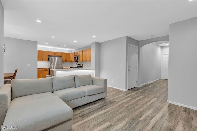 9074 Maycott Ave, Las Vegas, NV 89148 - living room with arched walkways, light wood-style flooring, and recessed lighting