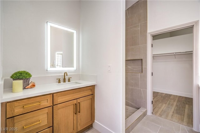 1144 Calico Ridge Dr, Henderson, NV 89011 - bathroom with vanity, tiled shower, a walk in closet, and tile patterned floors