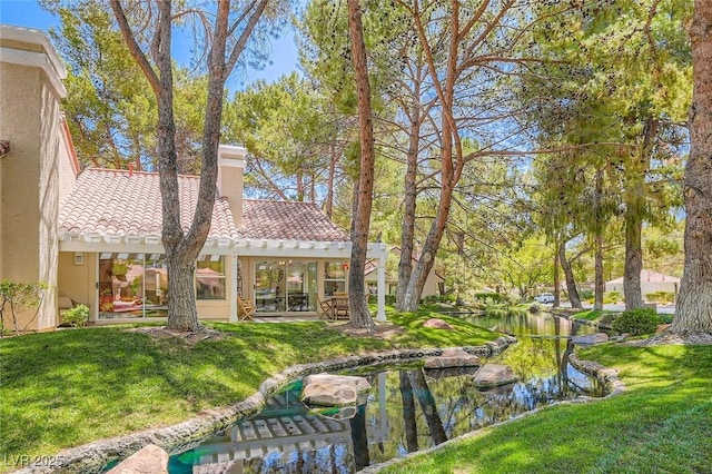 7068 Bright Springs Ct, Las Vegas, NV 89113 - view of grassy yard with a small pond and a patio area