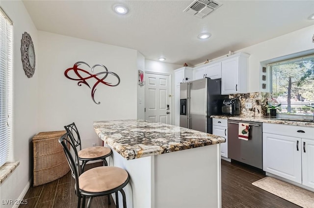 7068 Bright Springs Ct, Las Vegas, NV 89113 - kitchen with stainless steel appliances, a kitchen bar, a center island, recessed lighting, and white cabinets