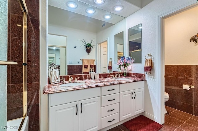 7068 Bright Springs Ct, Las Vegas, NV 89113 - bathroom with tile walls, double vanity, tile patterned floors, recessed lighting, and a wainscoted wall