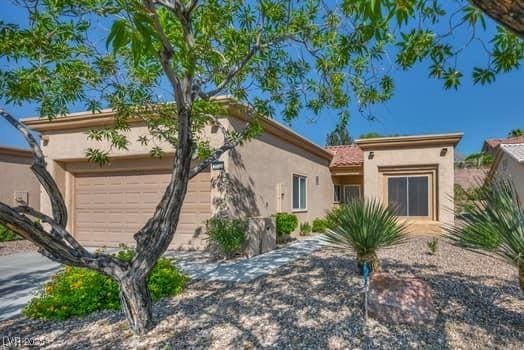 2135 Hallston St, Las Vegas, NV 89134 - view of front facade with stucco siding and a garage