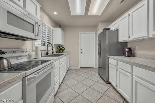 2135 Hallston St, Las Vegas, NV 89134 - kitchen featuring white appliances, white cabinetry, light countertops, and recessed lighting
