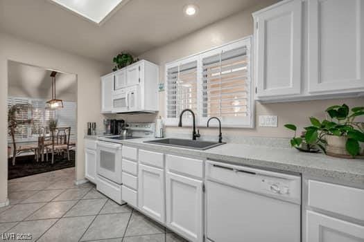 2135 Hallston St, Las Vegas, NV 89134 - kitchen with white appliances, white cabinets, light tile patterned floors, and recessed lighting