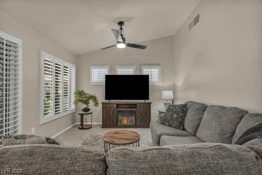 2135 Hallston St, Las Vegas, NV 89134 - living area featuring vaulted ceiling, ceiling fan, and a glass covered fireplace