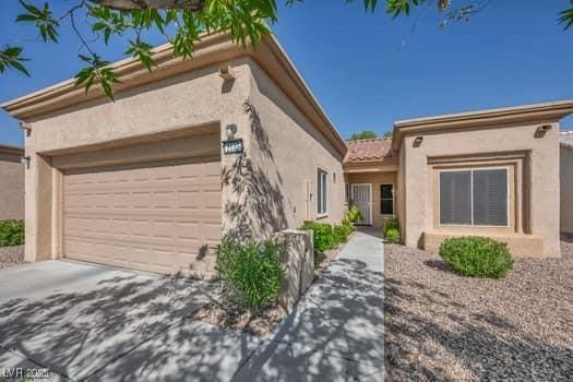 2135 Hallston St, Las Vegas, NV 89134 - view of front of home featuring stucco siding, a garage, and driveway