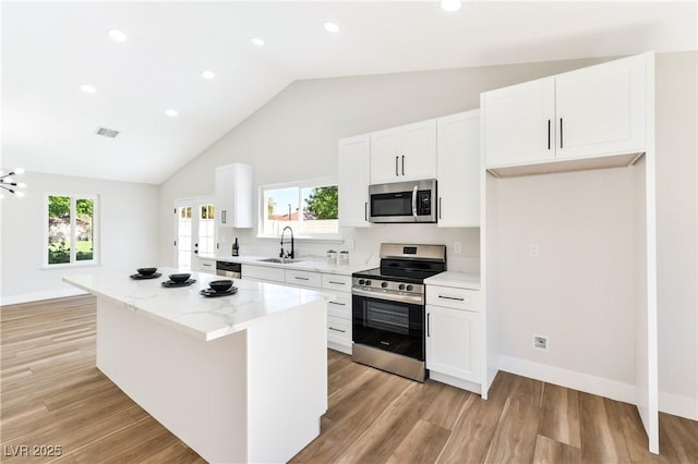 811 Spyglass Ln, Las Vegas, NV 89107 - kitchen featuring appliances with stainless steel finishes, a kitchen island, white cabinets, light wood-style floors, and recessed lighting