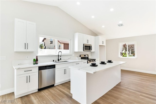 811 Spyglass Ln, Las Vegas, NV 89107 - kitchen with stainless steel appliances, white cabinets, plenty of natural light, light wood-style flooring, and recessed lighting