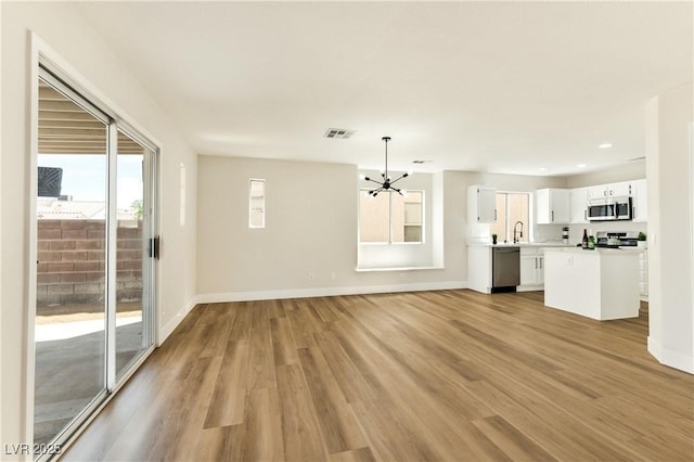 1724 Navajo Lake Way, Las Vegas, NV 89128 - unfurnished living room featuring a chandelier, light wood finished floors, and recessed lighting