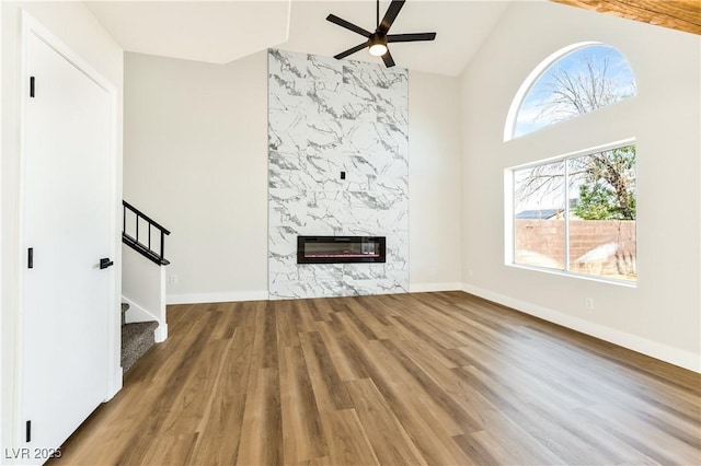 1724 Navajo Lake Way, Las Vegas, NV 89128 - unfurnished living room with ceiling fan, wood finished floors, a premium fireplace, stairs, and heating unit