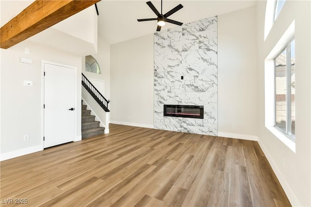 1724 Navajo Lake Way, Las Vegas, NV 89128 - unfurnished living room with ceiling fan, wood finished floors, stairs, heating unit, and a premium fireplace