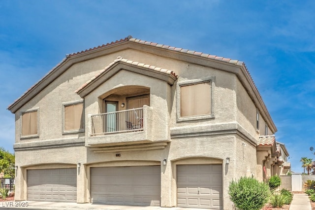 6068 Shyley St Unit 102, Henderson, NV 89011 - view of front of home with a balcony, an attached garage, stucco siding, and a tile roof