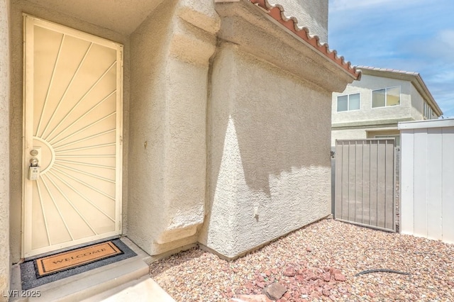 6068 Shyley St Unit 102, Henderson, NV 89011 - view of exterior entry featuring stucco siding, a tiled roof, and a gate
