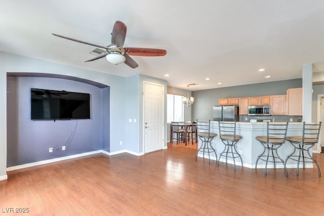 6068 Shyley St Unit 102, Henderson, NV 89011 - kitchen with appliances with stainless steel finishes, light brown cabinetry, a kitchen breakfast bar, light wood-style flooring, and recessed lighting