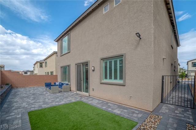 10189 Magnolia Creek St, Las Vegas, NV 89141 - back of property featuring stucco siding, a patio area, a fenced backyard, a gate, and an outdoor living space
