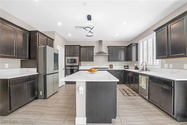 10189 Magnolia Creek St, Las Vegas, NV 89141 - kitchen featuring wall chimney exhaust hood, appliances with stainless steel finishes, a kitchen island, light stone countertops, and light tile patterned flooring
