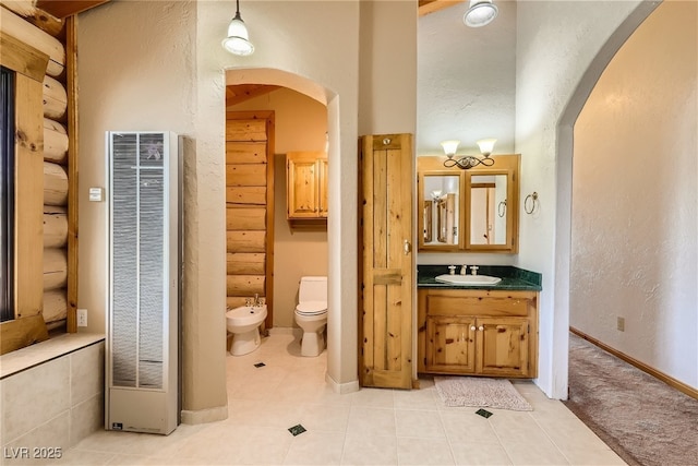 7790 Scottie St, Las Vegas, NV 89166 - bathroom with a heating unit, a bidet, vanity, log walls, and tile patterned flooring