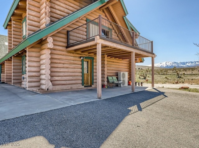 7790 Scottie St, Las Vegas, NV 89166 - back of house with log exterior, a mountain view, and a balcony