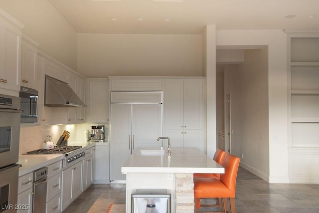 9 Knob Oak Dr, Henderson, NV 89052 - kitchen with stainless steel appliances, ventilation hood, built in features, light countertops, and a kitchen bar