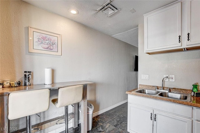 3912 Palos Verdes St, Las Vegas, NV 89119 - kitchen featuring white cabinets, dark stone finish floors, a textured wall, and a textured ceiling