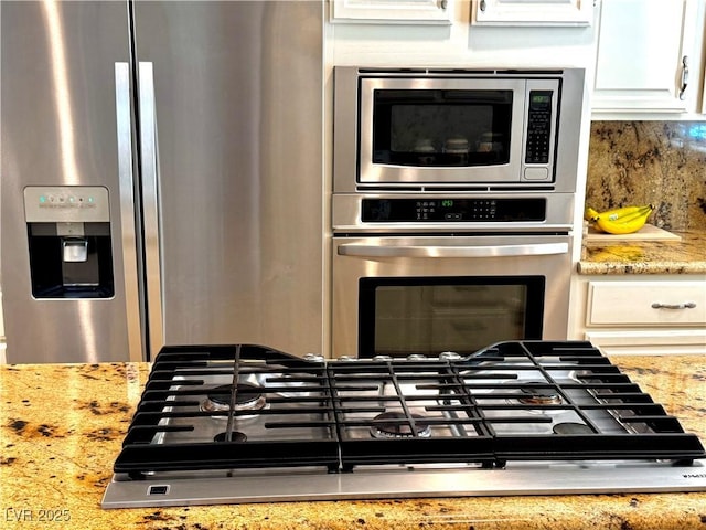 2975 Montessouri St, Las Vegas, NV 89117 - kitchen featuring stainless steel appliances, light stone counters, backsplash, and white cabinets