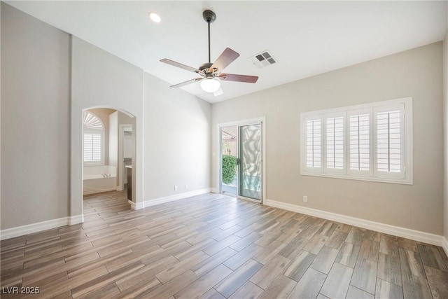 3882 Genoa Dr, Las Vegas, NV 89141 - spare room featuring arched walkways, a ceiling fan, plenty of natural light, light wood-type flooring, and recessed lighting