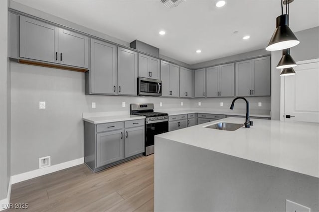 514 Fairview Hills St, Las Vegas, NV 89138 - kitchen with stainless steel appliances, gray cabinetry, recessed lighting, light wood-style floors, and decorative light fixtures
