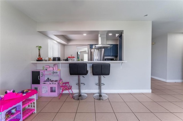 2690 Diamante Cir, Las Vegas, NV 89121 - kitchen with ventilation hood, a kitchen breakfast bar, light tile patterned flooring, freestanding refrigerator, and light countertops