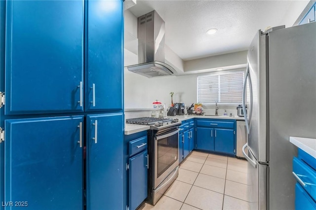 2690 Diamante Cir, Las Vegas, NV 89121 - kitchen featuring stainless steel appliances, island range hood, blue cabinetry, light tile patterned floors, and a textured ceiling