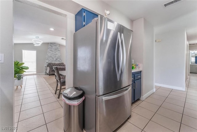 2690 Diamante Cir, Las Vegas, NV 89121 - kitchen featuring freestanding refrigerator, blue cabinetry, light tile patterned flooring, and plenty of natural light