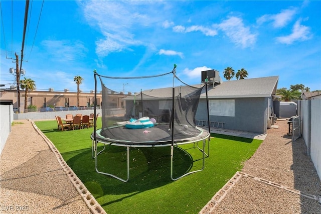 2690 Diamante Cir, Las Vegas, NV 89121 - rear view of house with a trampoline and a fenced backyard