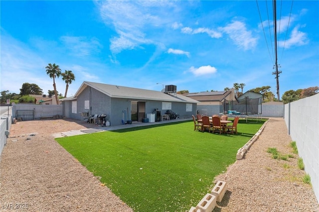 2690 Diamante Cir, Las Vegas, NV 89121 - back of property with a trampoline, a patio area, stucco siding, and a fenced backyard